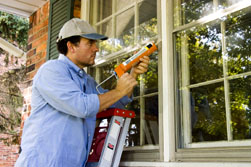 man fixing home windows exterior