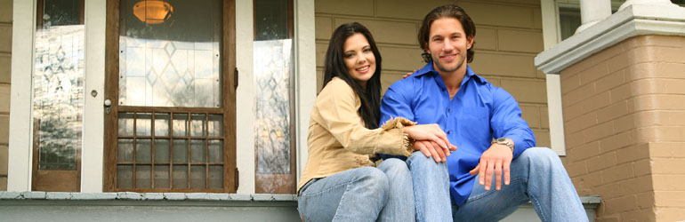 couple sitting on front porch of home